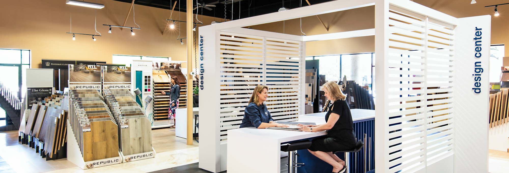 Landers Premier Flooring - Owner, Stephanie Landers, sitting at the main consultation Desk with a customer.